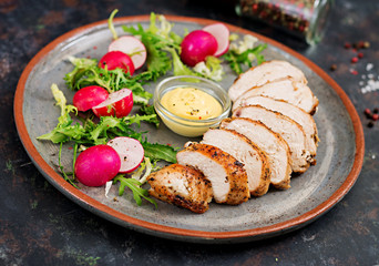Baked chicken breast and fresh vegetables on the plate on a dark background. Proper nutrition. Dietary menu.
