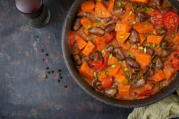 Chicken hearts with pumpkin and tomatoes in tomato sauce. Flat lay. Top view