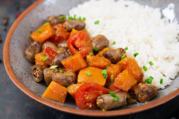 Chicken hearts with pumpkin and tomatoes in tomato sauce. The garnish is served with boiled rice.