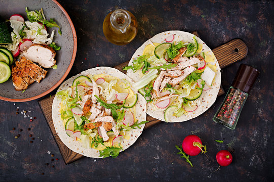 Healthy mexican tacos with baked chicken breast, cucumber, radish and lettuce. Flat lay. Top view