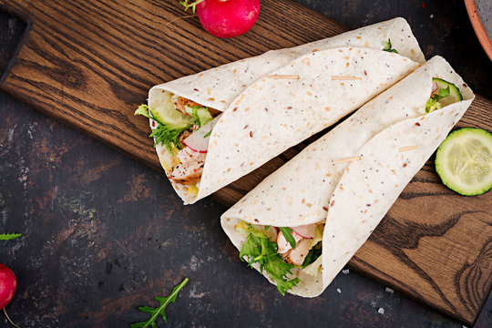 Healthy mexican tacos with baked chicken breast, cucumber, radish and lettuce. Flat lay. Top view