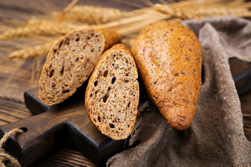 Buns of whole-grain flour with the addition of flax seeds on a wooden background.