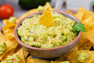 Guacamole avocado, lime, tomato, onion and cilantro, served with nachos - Traditional Mexican snack. 