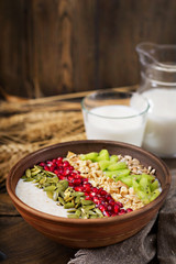 Delicious and healthy oatmeal with kiwi, pomegranate and seeds. Healthy breakfast. Fitness food. Proper nutrition. Rustic style