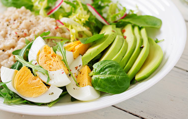 Healthy breakfast. Dietary menu. Oatmeal porridge and avocado salad and eggs.