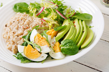 Healthy breakfast. Dietary menu. Oatmeal porridge and avocado salad and eggs.