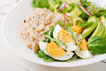 Healthy breakfast. Dietary menu. Oatmeal porridge and avocado salad and eggs.