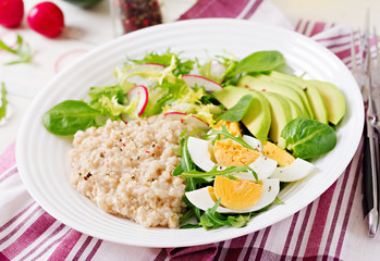 Healthy breakfast. Dietary menu. Oatmeal porridge and avocado salad and eggs.