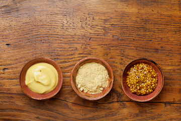 Obraz na płótnie Canvas Set of different spices. French mustard, dijon mustard and powder on wooden rustic table top view.