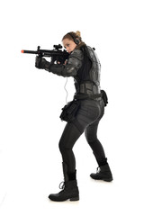full length portrait of female  soldier wearing black  tactical armour, holding a rifle gun, isolated on white studio background.