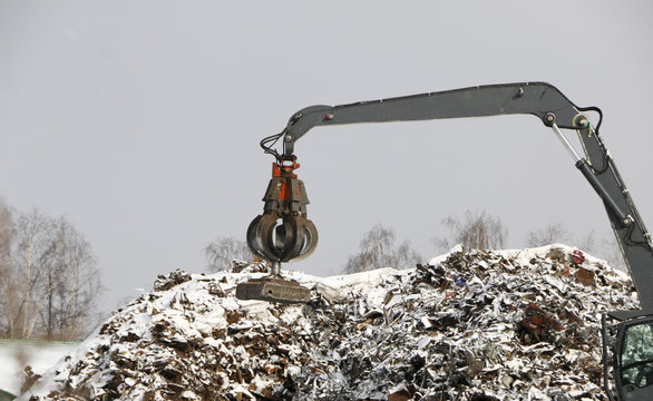 The hydraulic grab cleans and tampens the metal debris. The excavator lifts and throws the load with a pneumatic paw with claws.