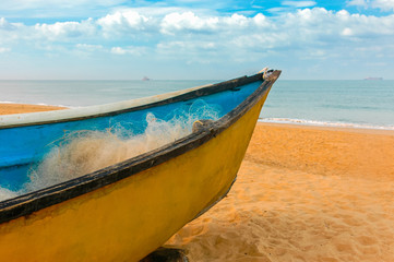 Naklejka premium Yellow fishing boat on the shores of the Indian ocean. Goa. India. Vacation holidays travel background wallpaper