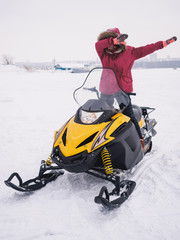 Girl in the snowmobile. Winter snow field