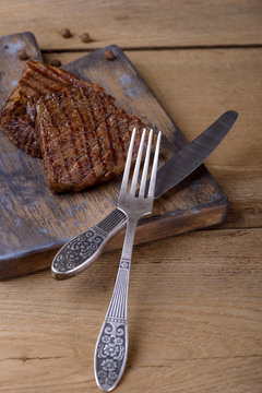 Two roasted beef steak and fork with knife