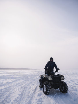 Man in atv quad bike. Winter snow field
