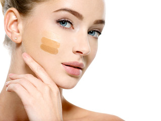 Young woman with cosmetic foundation on skin.