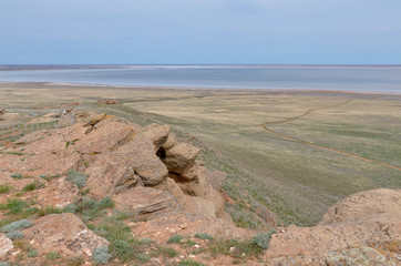 carved sandstone outcrops of Big Bogdo sacred mountain and Baskunchak salt lake in vast grasslands...