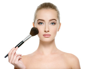 Young girl  with makeup brush near at face