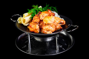 Fried grilled meats with vegetables on a black background