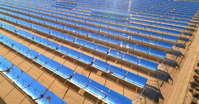 Aerial flyover view of a solar farm producing clean renewable sun energy in California, industrial landscape
