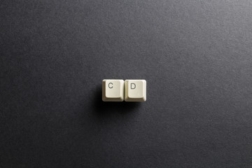 Word CD made using computer keyboard buttons on a black background. Compact disk. IT technology concept.