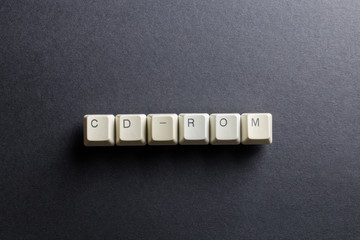Word CD-ROM made using computer keyboard buttons on a black background. Compact disk. IT technology concept.
