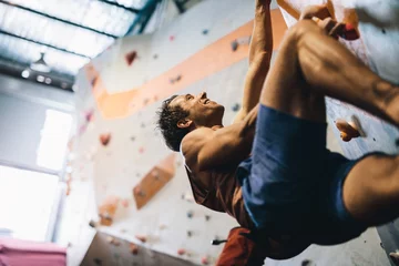Zelfklevend Fotobehang Man climbing indoor boulder wall © Jacob Lund