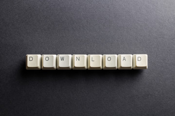 Word download made using computer keyboard buttons on a black background. Receive data from a remote system. IT technology concept.