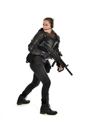 full length portrait of female  soldier wearing black  tactical armour, holding a rifle gun, isolated on white studio background.