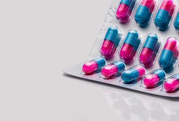 Colorful of blue, pink capsule with granule in side pills. Pills in blister pack on white...