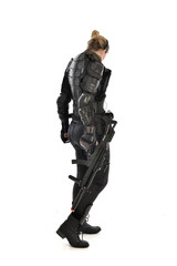 full length portrait of female  soldier wearing black  tactical armour, holding a rifle gun, isolated on white studio background.
