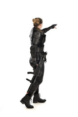 Obraz premium full length portrait of female soldier wearing black tactical armour, holding a rifle gun, isolated on white studio background.