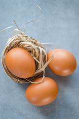 Raw chicken eggs on gray background.