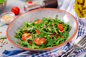 Dietary menu. Vegan cuisine. Healthy salad with arugula, tomatoes and pine nuts.