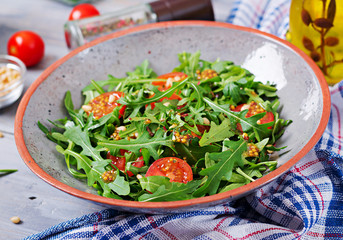 Dietary menu. Vegan cuisine. Healthy salad with arugula, tomatoes and pine nuts.