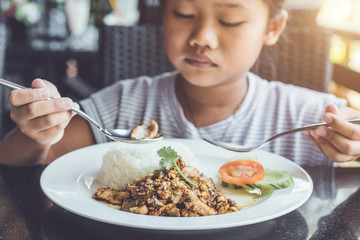Thai children eating in restaurant. Bored with food concept
