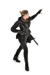 full length portrait of female  soldier wearing black  tactical armour, holding a rifle gun, isolated on white studio background.