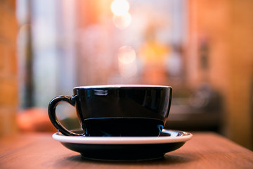 Hot coffee cup on wooden table with blur background