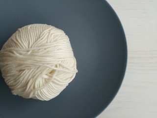 White yarn ball on dark blue plate