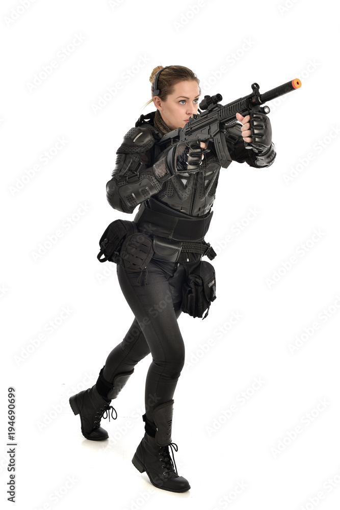 Sticker full length portrait of female  soldier wearing black  tactical armour, holding a rifle gun, isolated on white studio background.