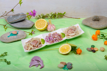 raw fish with onions in a composition on a green background