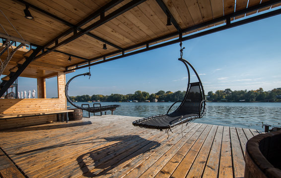 Outdoor hammocks on terrace of house by river