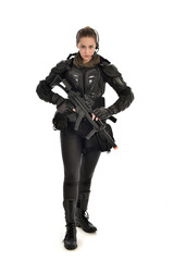 full length portrait of female  soldier wearing black  tactical armour, holding a rifle gun, isolated on white studio background. © faestock