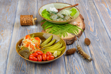 Pickles tomatoes and mushrooms in a composition on a wooden background