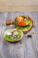 Pickles tomatoes and mushrooms in a composition on a wooden background