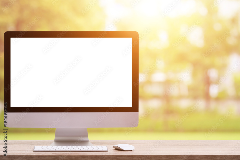 Poster Modern desktop computer on wooden table and abstract light blur and bokeh background. Saved with clipping path