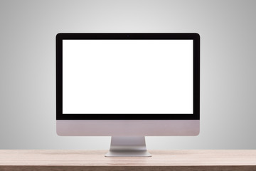 Modern desktop computer on wooden table. Studio shot isolated on blank grey. Blank screen for graphics display montage