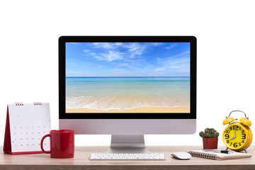 Modern desktop computer, Coffee cup, alarm clock, notebook and calendar on wooden table. Studio shot isolated on white. Saved with clipping path Blank screen for graphics display montage