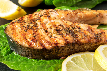 Salmon fillet. Grilled salmon with herb and lemon on black slate board.