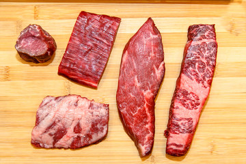 A lot of different steaks of marbled beef lies on the Board, rib eye, tenderloin, Striploin, machete, diaphragm.